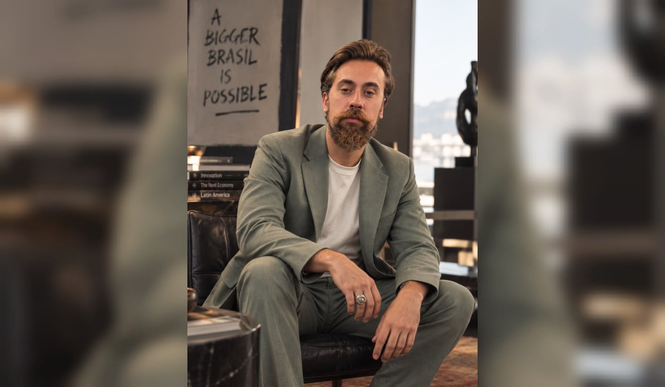Dr. Kauan von Novack seated in a sage suit and white T-shirt
